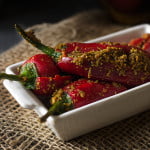 Whole Bharwan Lal Mirch ka Achar arranged on a plate, showcasing vibrant red chilies stuffed with spices