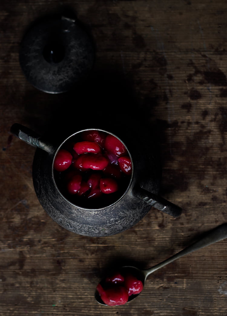 Overhead view of cherry compote in a glass container