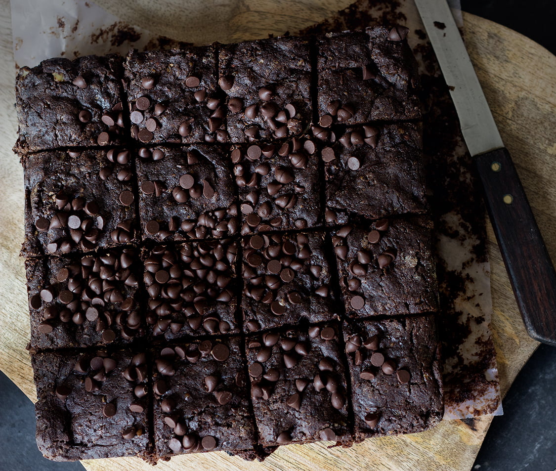 A plate of rich, fudgy cucumber brownies topped with the chocolate nuts