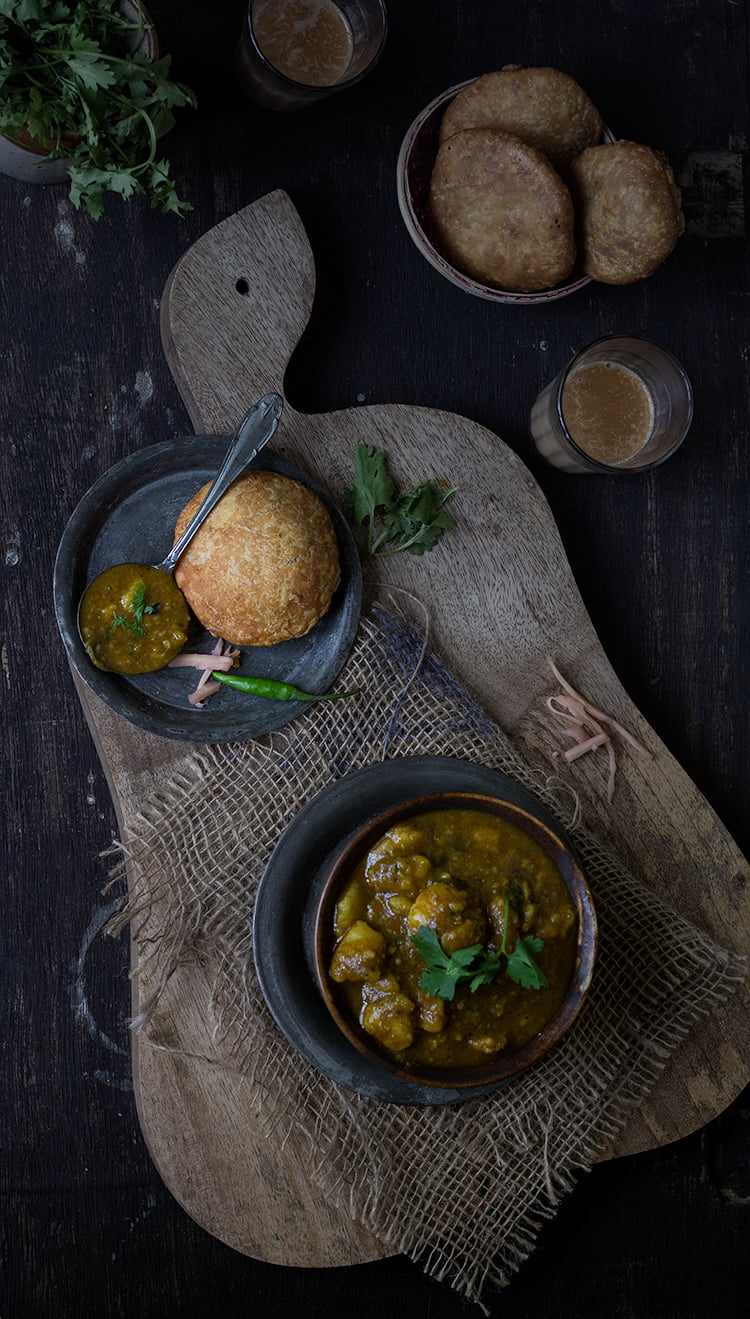 Mathura ke Dubki Wale Aloo served with poori on a traditional plate