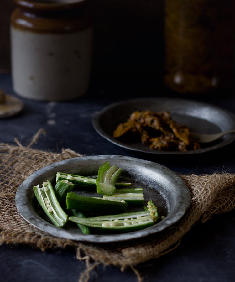 Sliced okra pieces arranged on a cutting board for the pickling process