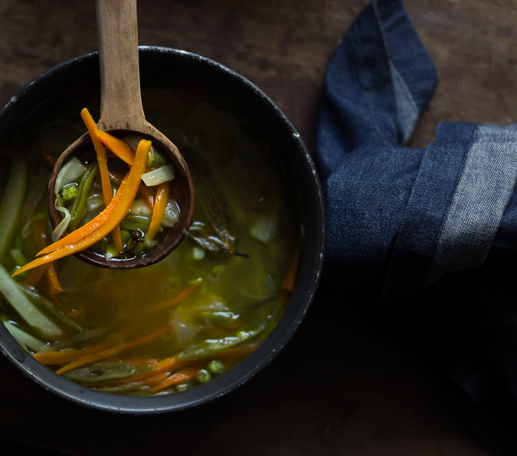 Bowl of healthy vegetable soup garnished with fresh coriander