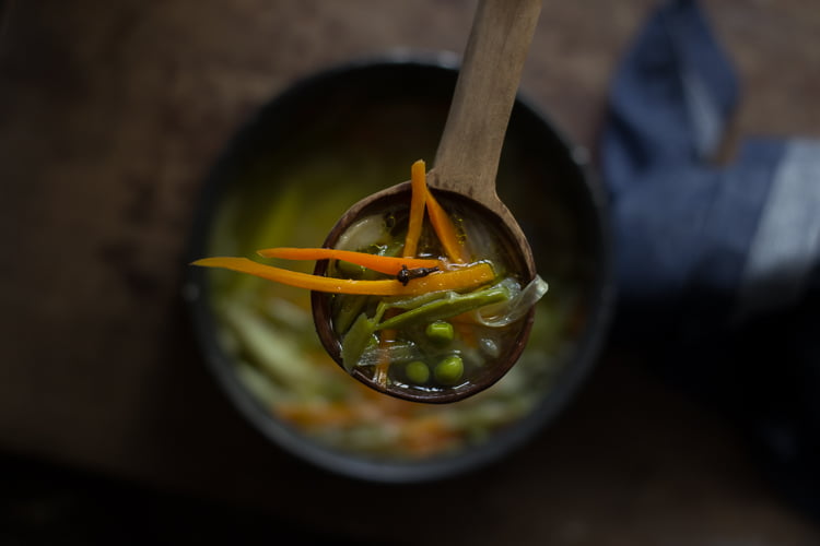 Close-up of hot Indian veg soup with colorful chopped vegetables