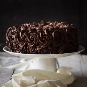 A whole Tiramisu Cake garnished with chocolate curls