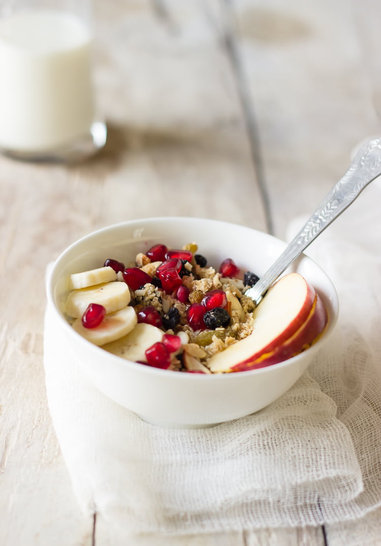 A bowl filled with healthy homemade granola with the slices of apple and bananas