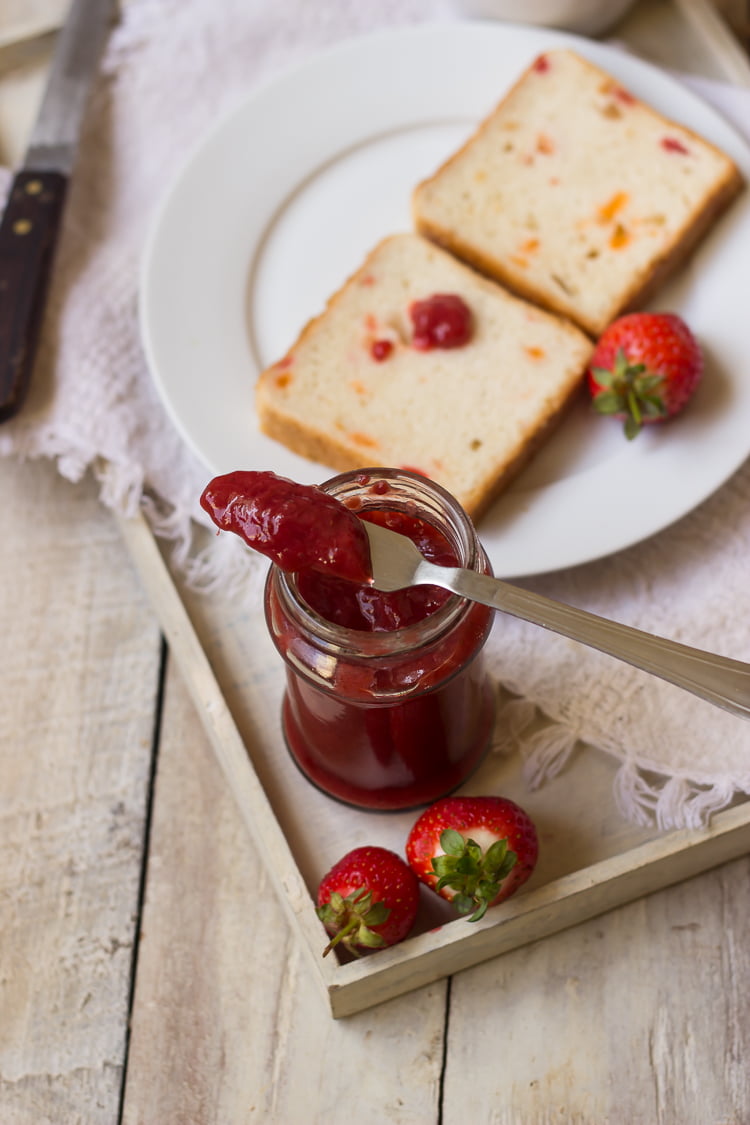 Thick strawberry jam cooling in a glass jar
