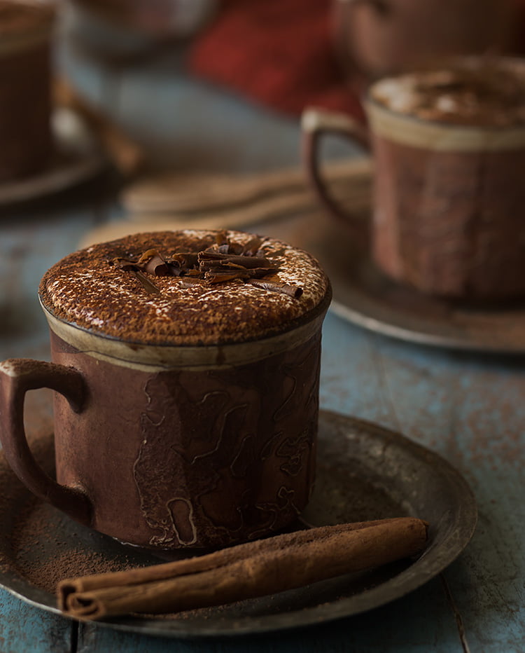 Close-up of a steaming cup of rich homemade hot chocolate topped with whipped cream
