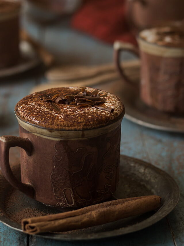 Close-up of a steaming cup of rich homemade hot chocolate topped with whipped cream