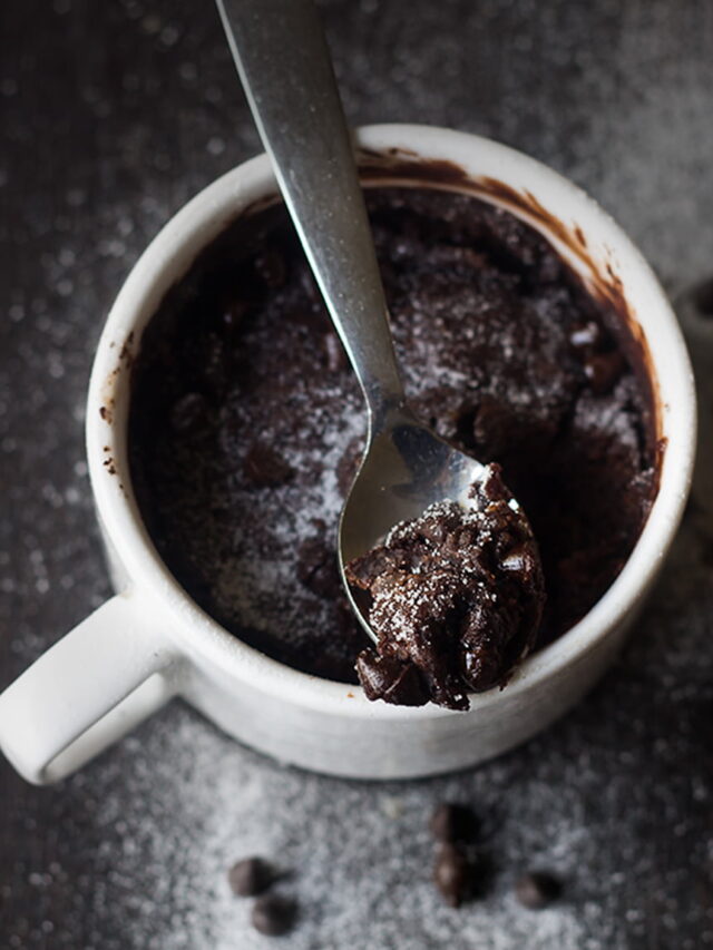 Close-up of gooey brownie in a white ceramic mug.