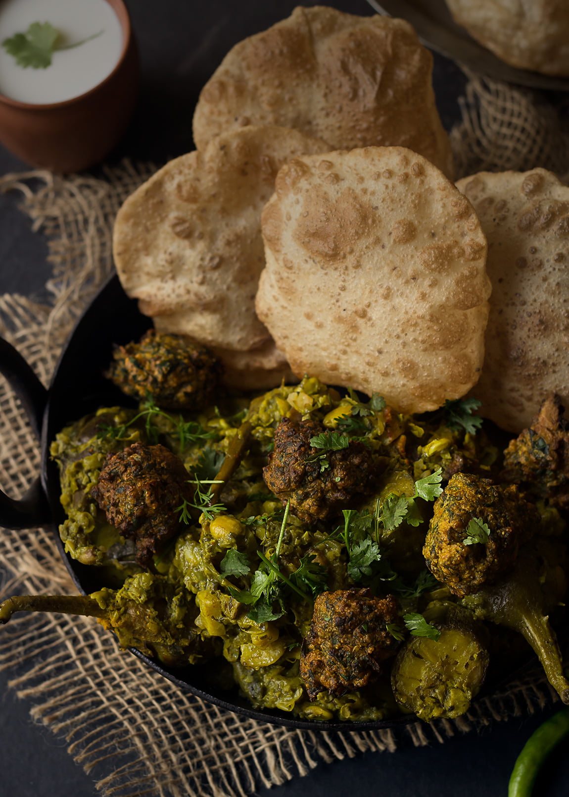Serving of Undhiyu with a side of  hot fried puris
