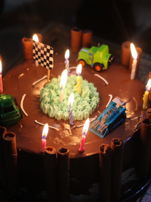 A beautifully decorated race track cake with vibrant toy cars, perfect for a kids' birthday party