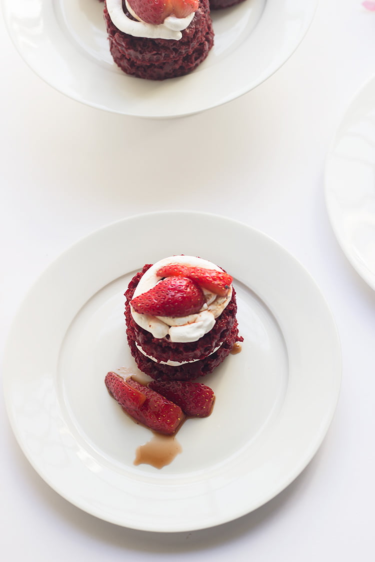 Individual red velvet mini cake topped with swirls of cream cheese frosting