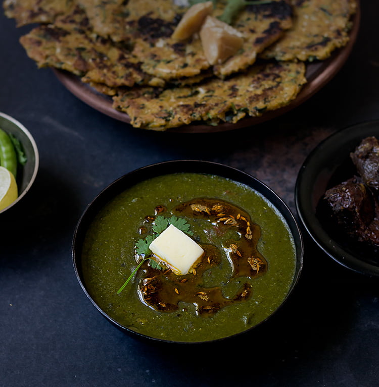 Traditional Sarson Ka Saag with a glossy buttery topping, ready to be served
