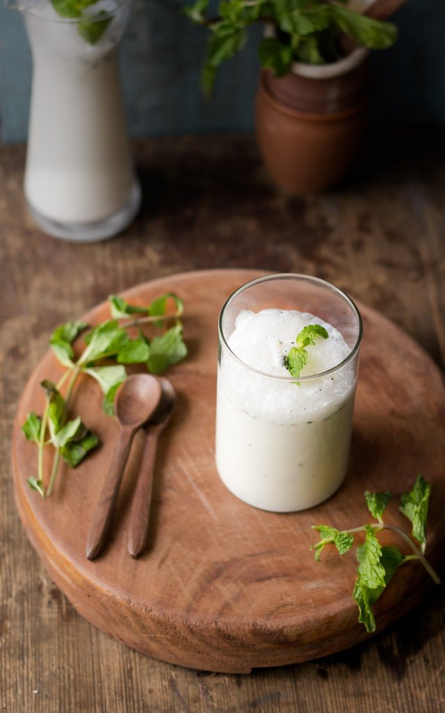 Top view of masala chaas in an earthen clay glass with mint leaves