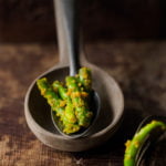 A close-up shot of vibrant green chilli pickle showcasing its spicy and tangy texture