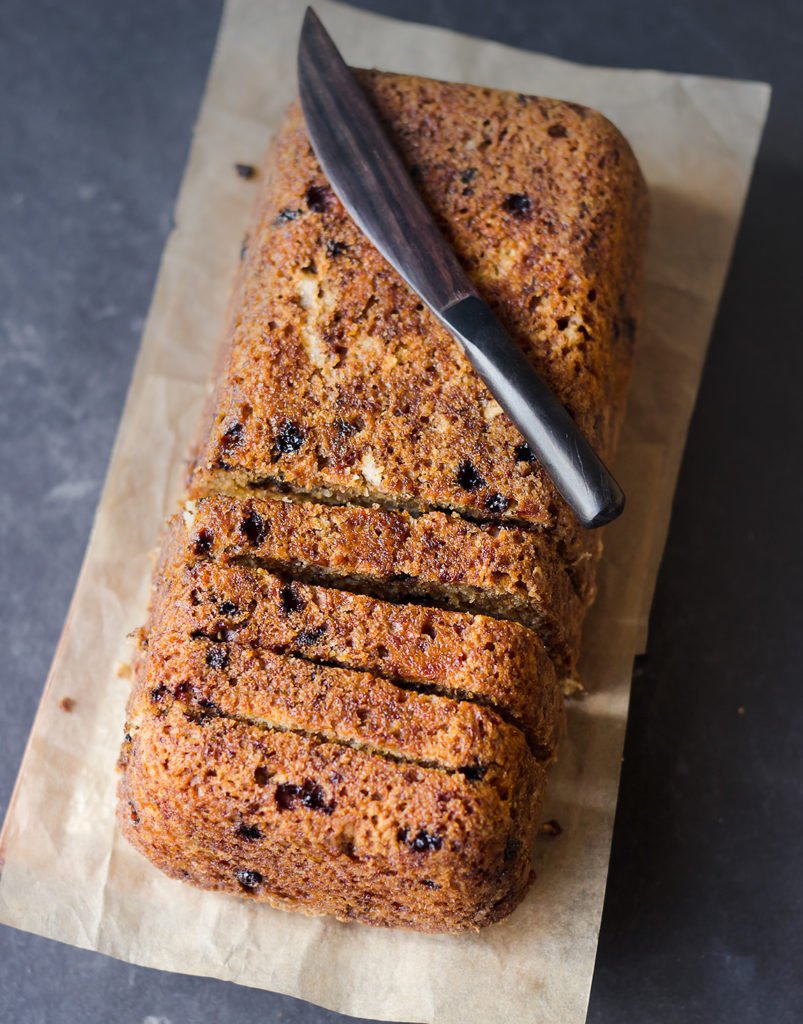 Freshly baked banana walnut bread loaf on a wooden board