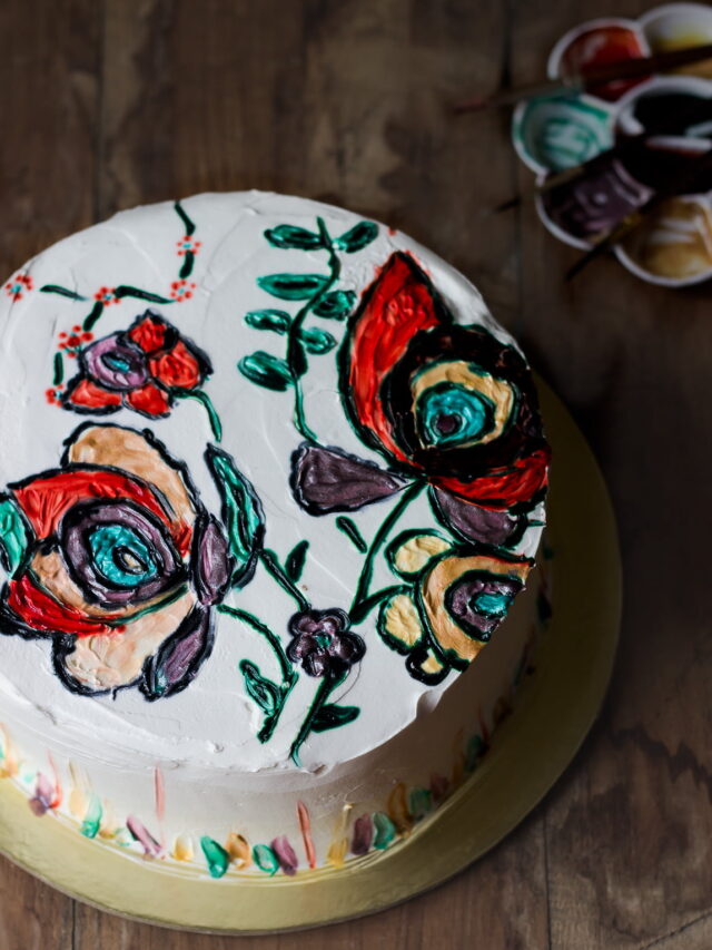 A top view of the entire eggless hand-painted cake, displaying vibrant hand-painted patterns and a smooth, fluffy texture