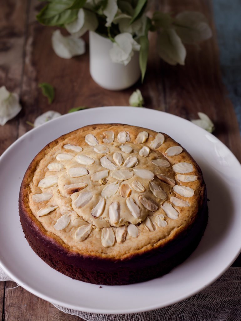 Top-down view of a perfectly round Eggless Mawa Cake on a wooden board

