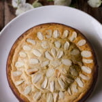 A whole Eggless Mawa Cake garnished with chopped nuts on top