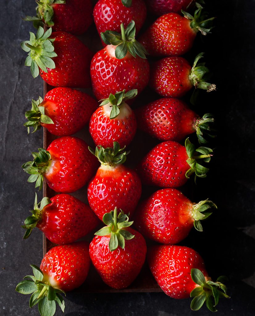 Close-up of fresh, ripe strawberries with vibrant red color and green leaves