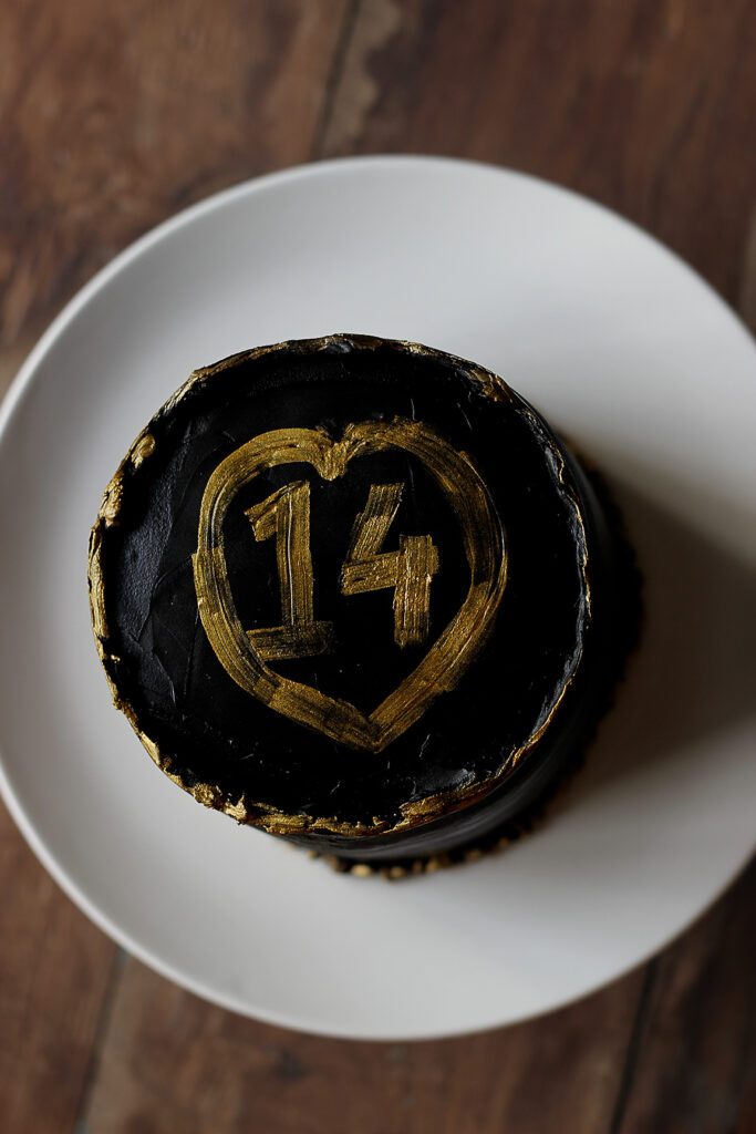 Top view of Black and Gold Chocolate Ganache Cake decorated with edible gold flakes and dark chocolate shards