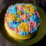 Close-up of intricate buttercream flowers on top of the eggless garden cake