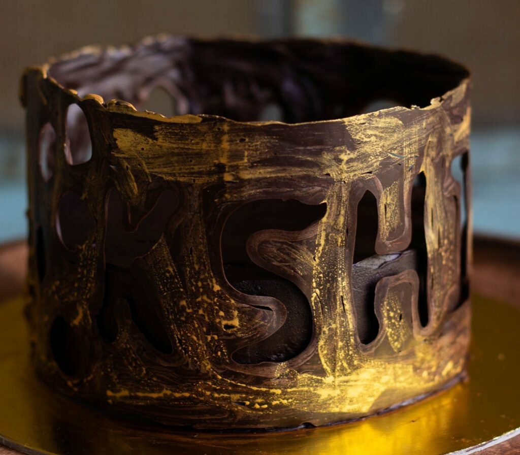 A beautifully decorated eggless chocolate collar cake with a glossy finish
