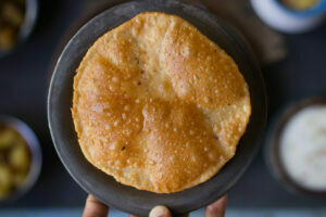 A freshly made Bedmi Puri puffing up as it fries in oil
