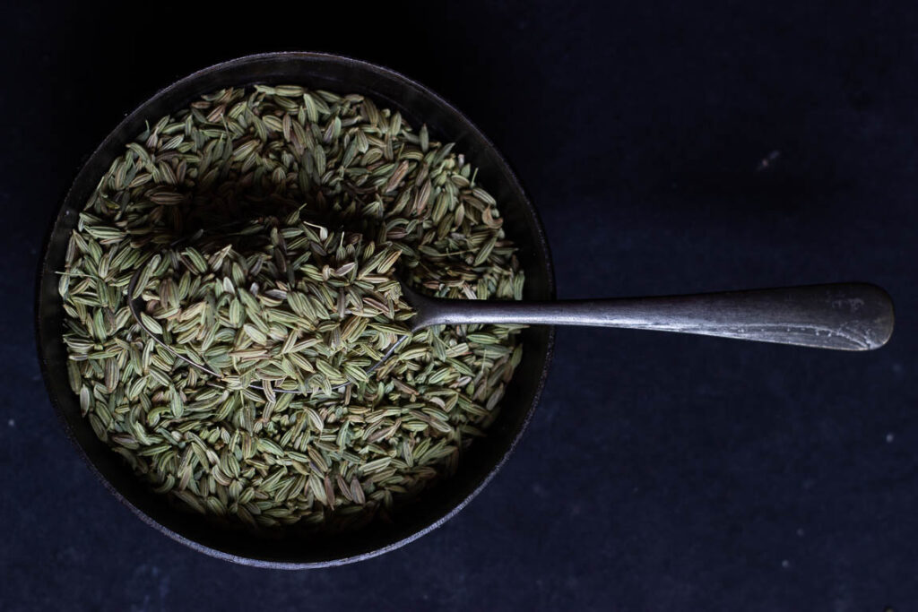 Coriander seeds and ground powder displayed in a traditional Indian kitchen