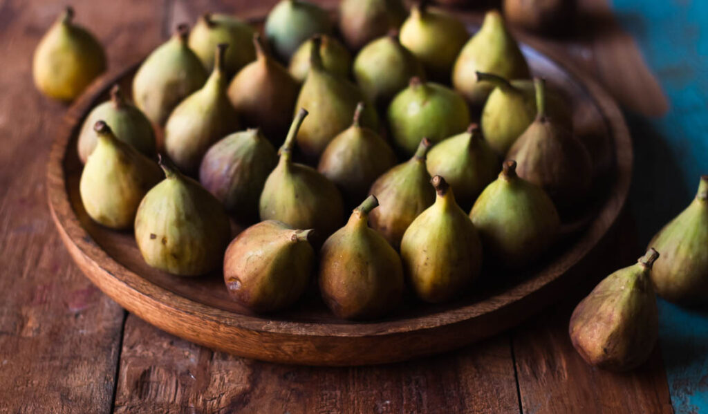 Figs on a wooden plate, emphasizing their complementary nutritional benefits