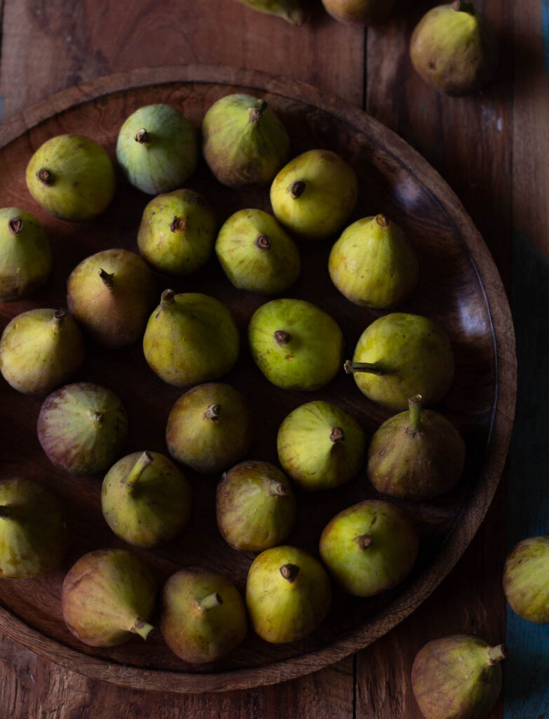 A bunch of figs placed on a wooden plate