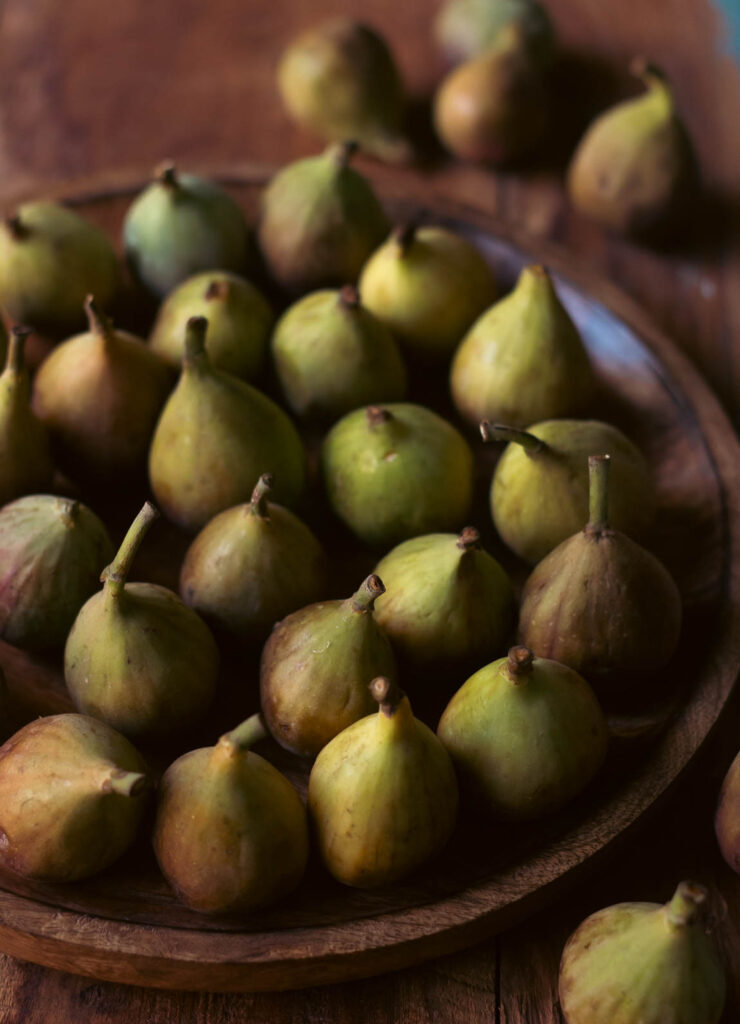 Top view of figsarranged in a wooden plate showcasing its nutritious nature