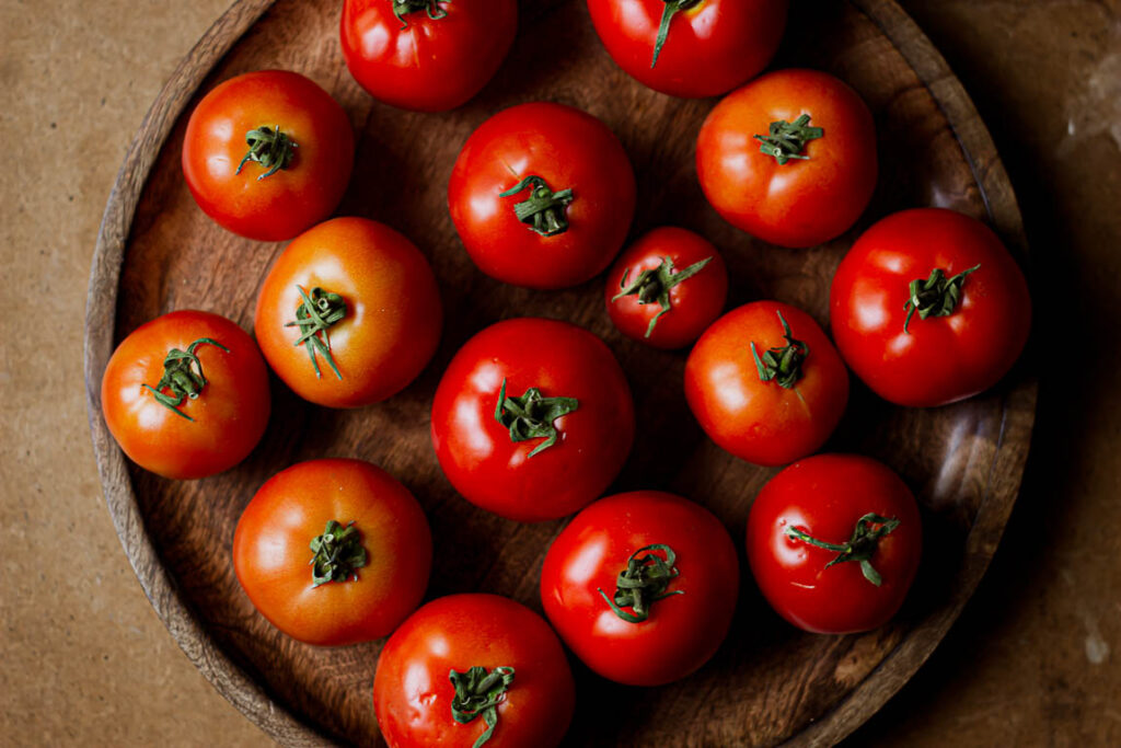 Fresh ripe tomatoes sliced and arranged on a cutting board
