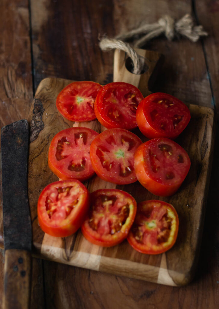 Close up of a sliced tomatoes place on a wooden tray 