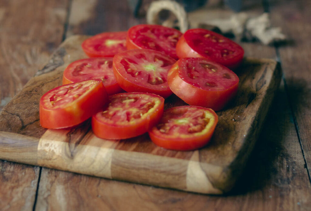 Tomatoes being arranged on a dehydrator tray for even drying