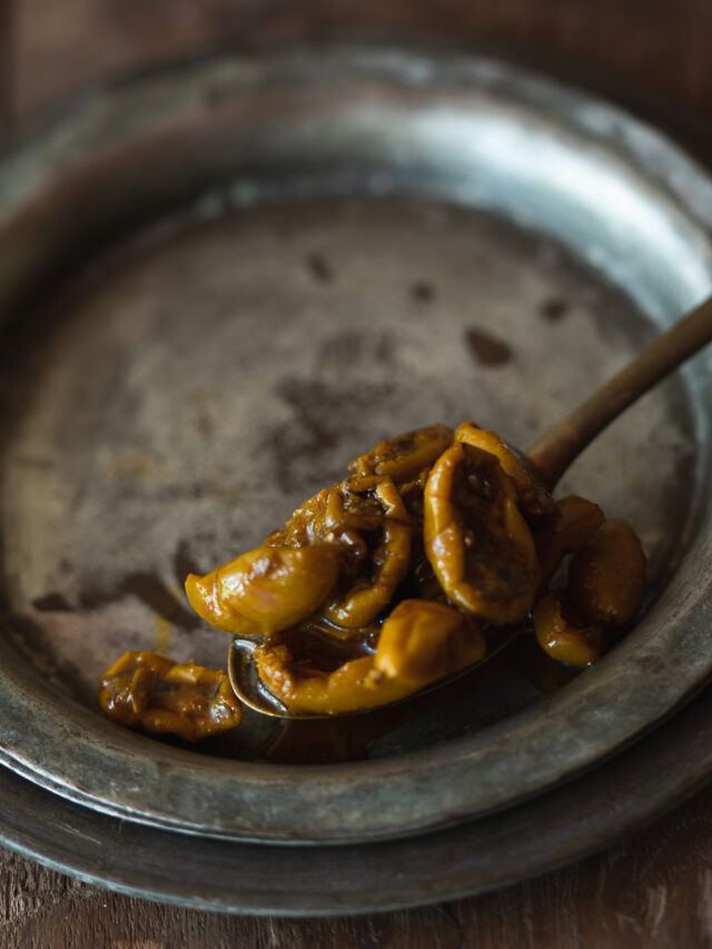 A jar of Karonde Ka Achar, filled with vibrant karonda pickles and spices