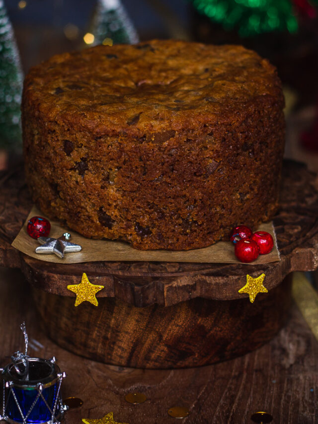 Brandied Christmas fruit cake on a festive platter with holiday decorations in the background