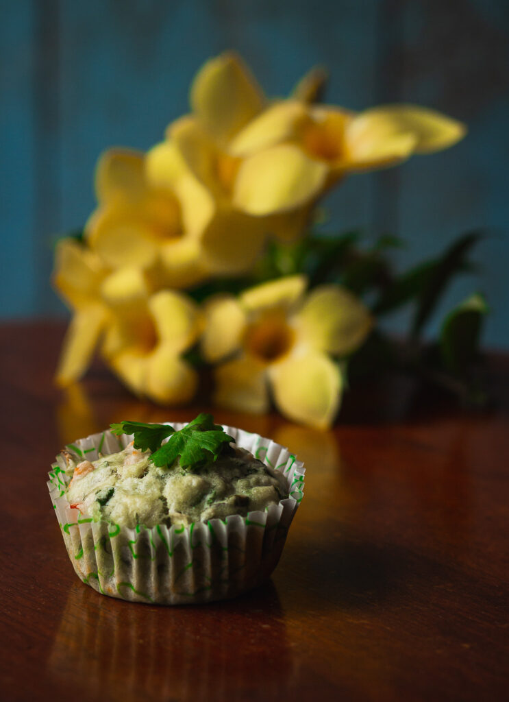 Close-up of a fluffy spinach and cheese muffin with melted cheese on top
