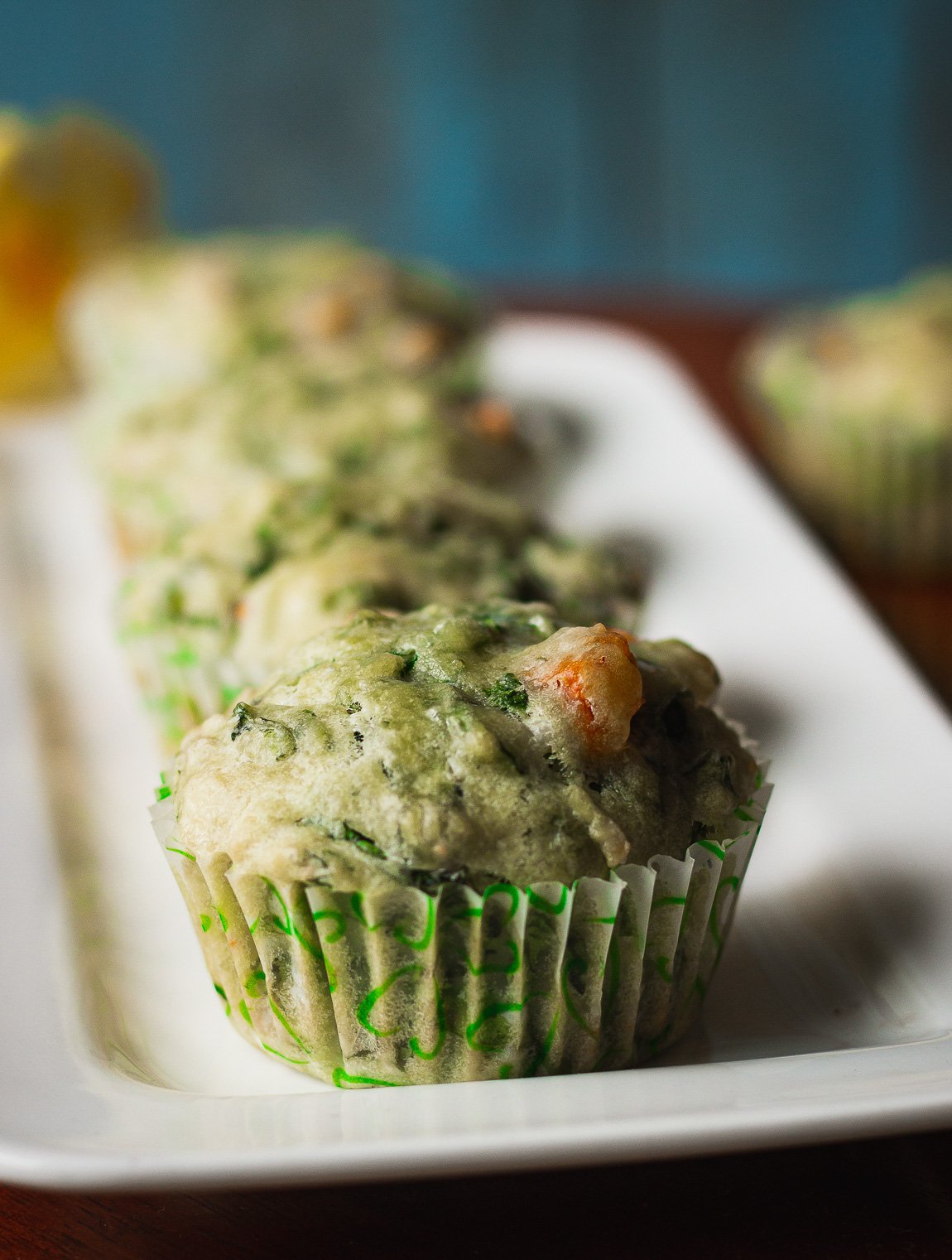 Close-up of a fluffy spinach and cheese muffin with melted cheese on top
