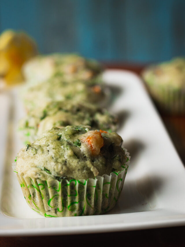 Freshly baked spinach cheese muffins on a wooden tray