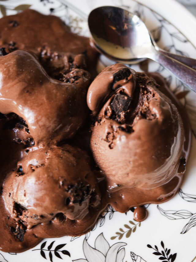 Homemade chocolate ice cream being scooped from a freezer-safe container