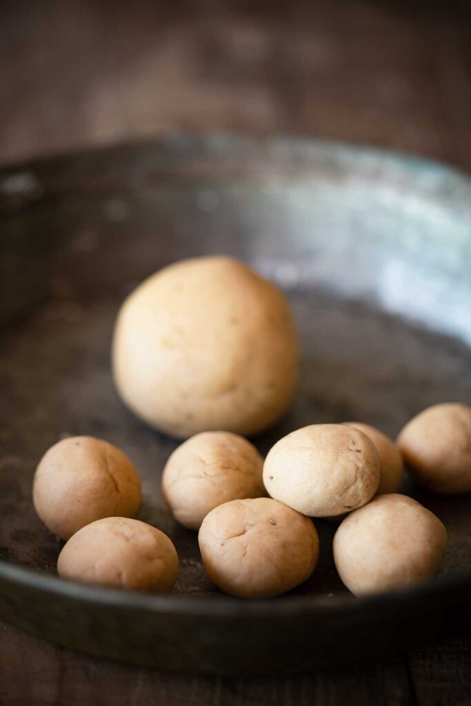 Making small balls of dough to make pooris